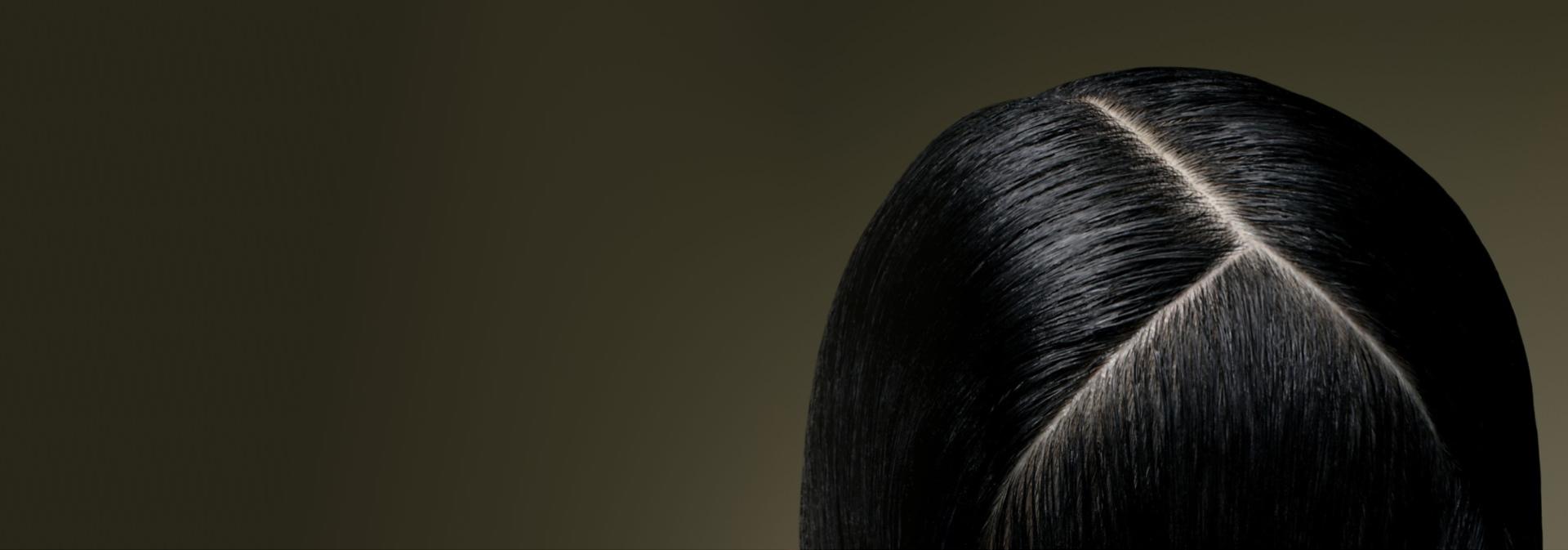 Top down view of a healthy scalp beneath straight hair.