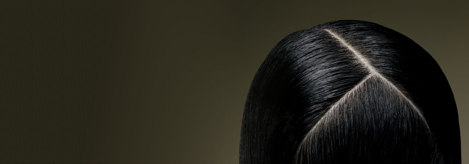 Top down view of a healthy scalp beneath straight hair.