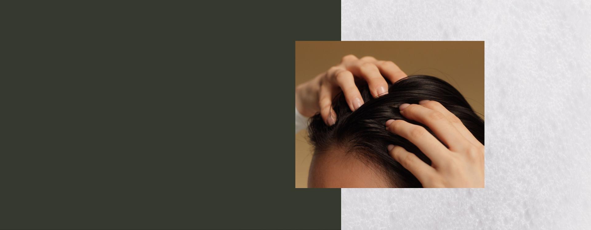 A model massages Dyson Amino leave-in scalp bubble treatment into her scalp.