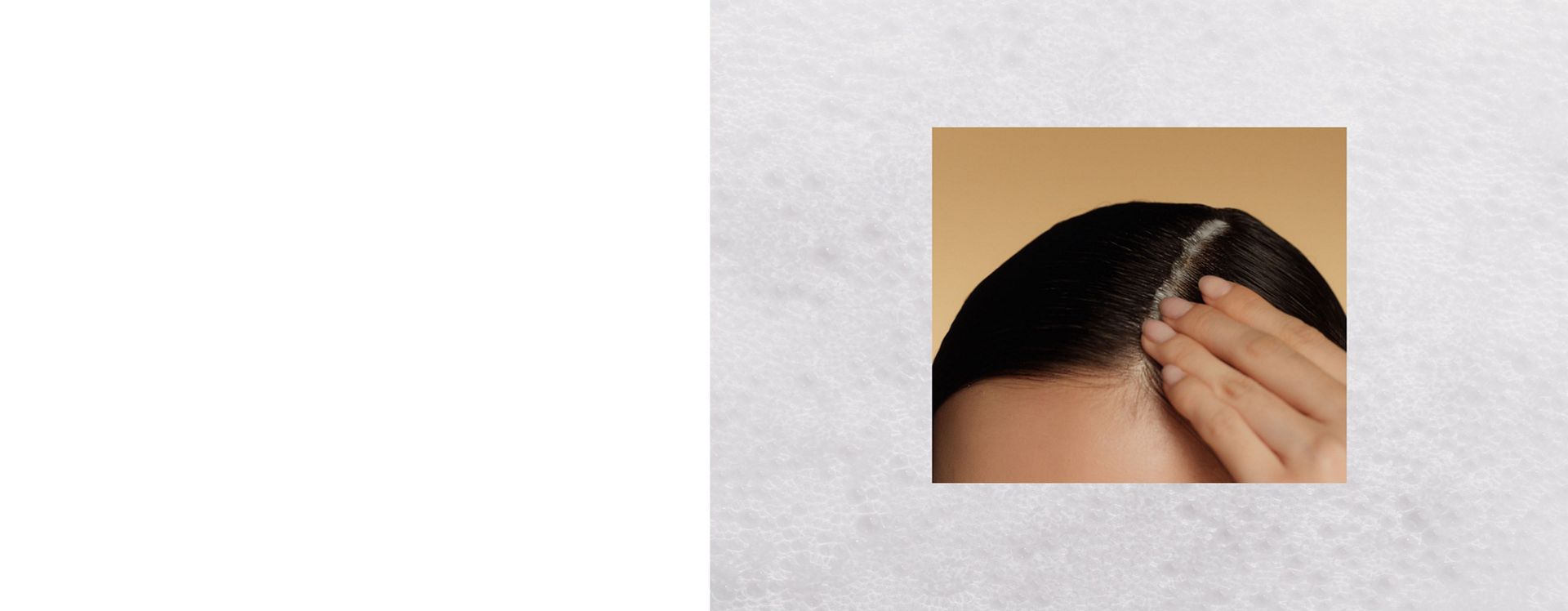 A model massages Dyson Amino leave-in scalp bubble treatment into their scalp.