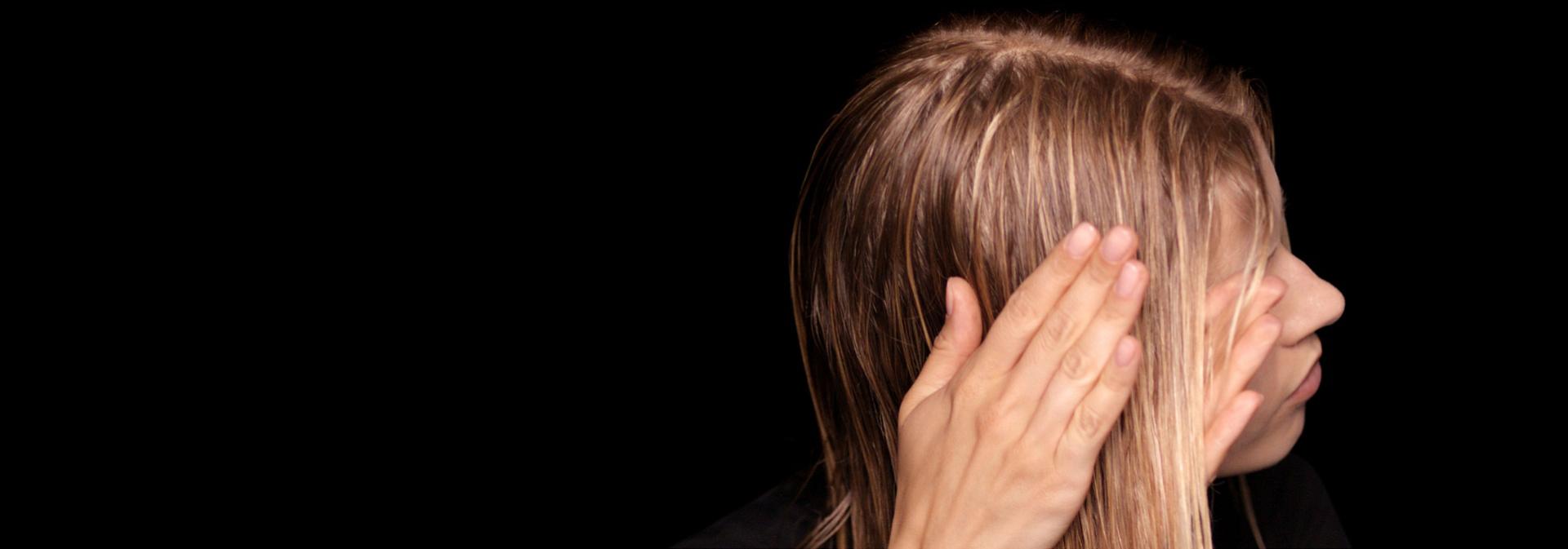 Blond modelka nanáší na své vlasy pre-stylingový krém Dyson Chitosan.