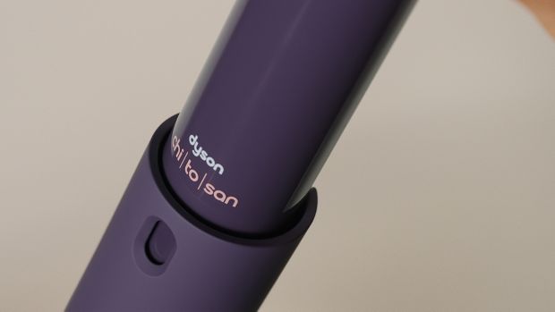 Distribuitorul interior de spray de coafare multifuncțional Dyson Chitosan este scos din flaconul cu spray.
