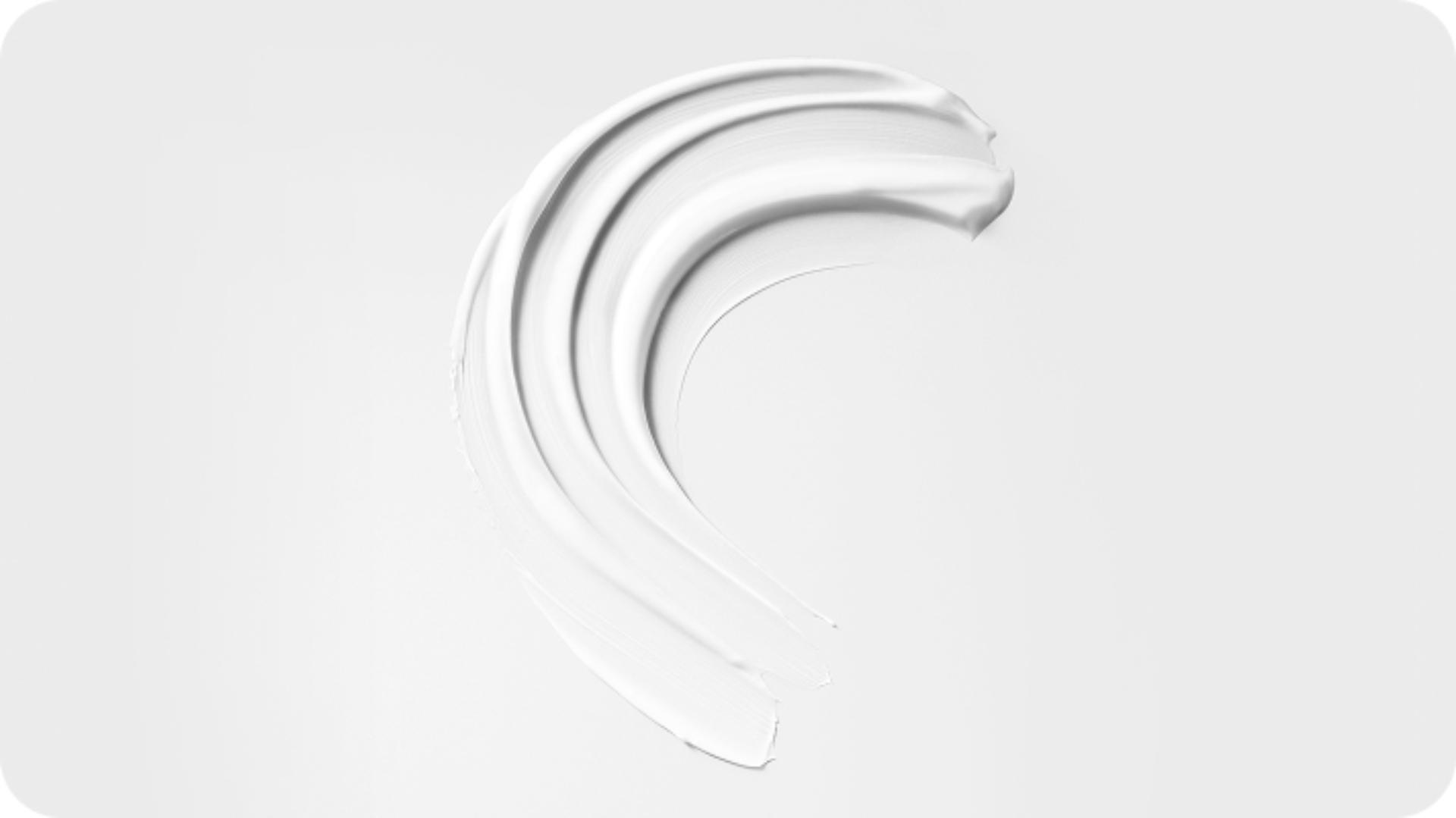 A swipe of pre-style cream on white background, showing texture.