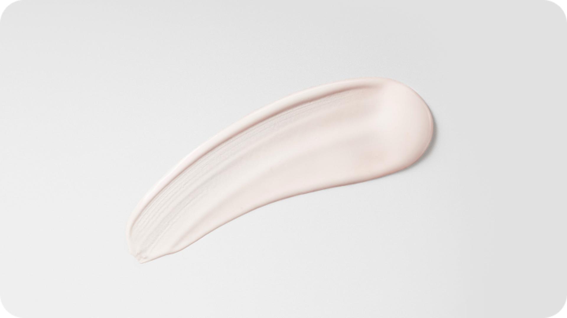 A swipe of post-style serum on white background, showing texture.