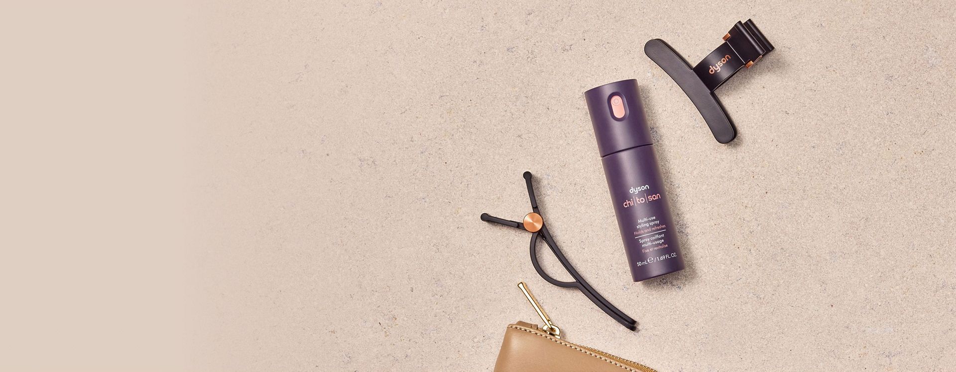 The Dyson Chitosan Multi-use styling spray travel mini with a set of Dyson hair clips.