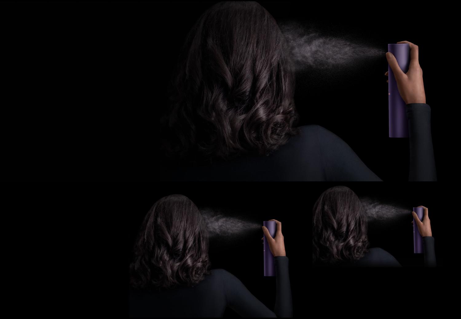 Model with dark hair applies Dyson Chitosan Multi-use styling spray to her hair.