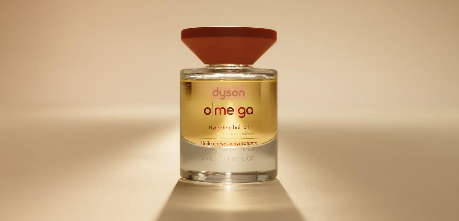 The Dyson Omega hydrating hair oil illuminated from behind with a warm glow.