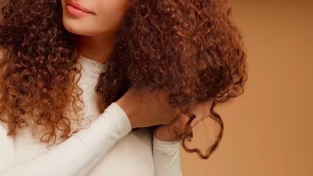Dyson Omega hydrating hair oil applied to hair.
