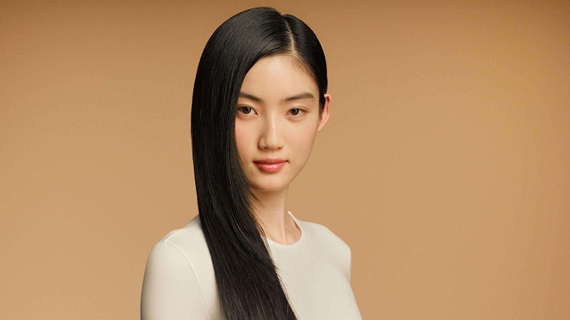 A model with sleek, straight, dark hair nourished with the Dyson Omega range.
