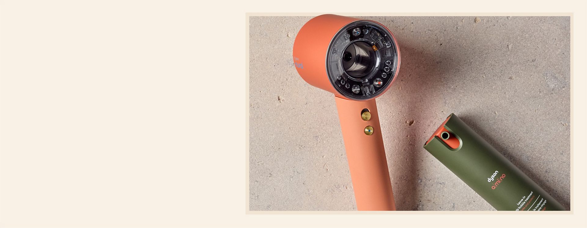 Dyson Supersonic Nural hair dryer and Dyson Amino leave-in scalp bubble treatment on a stony background.