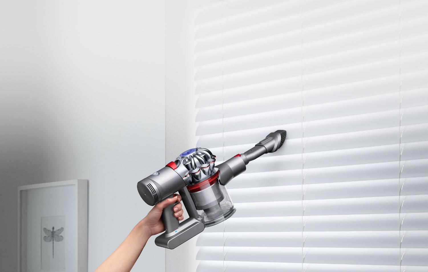 Dyson V7™ handheld vacuum on window blinds