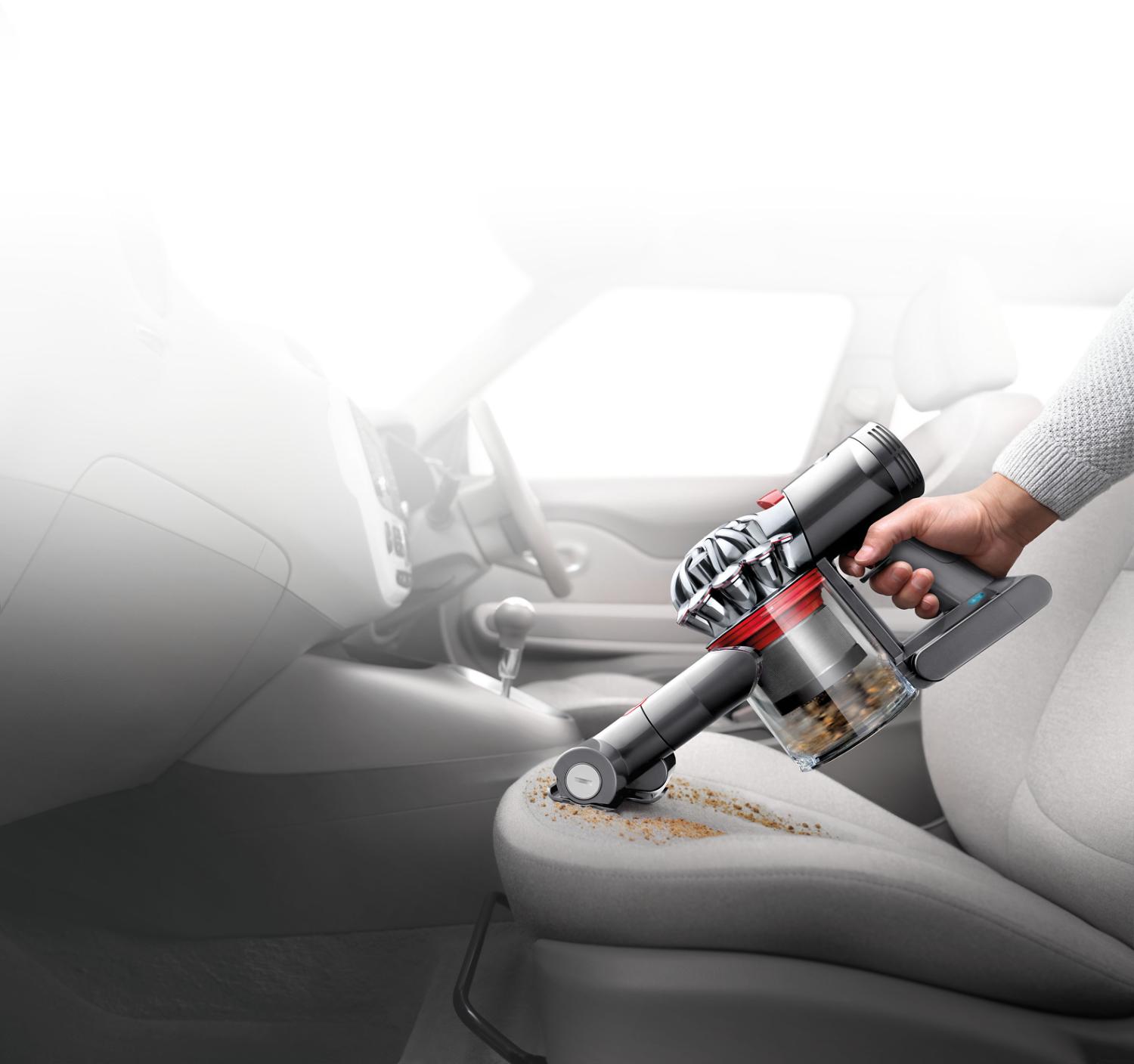 Dyson V7™ handheld cleaning a car interior