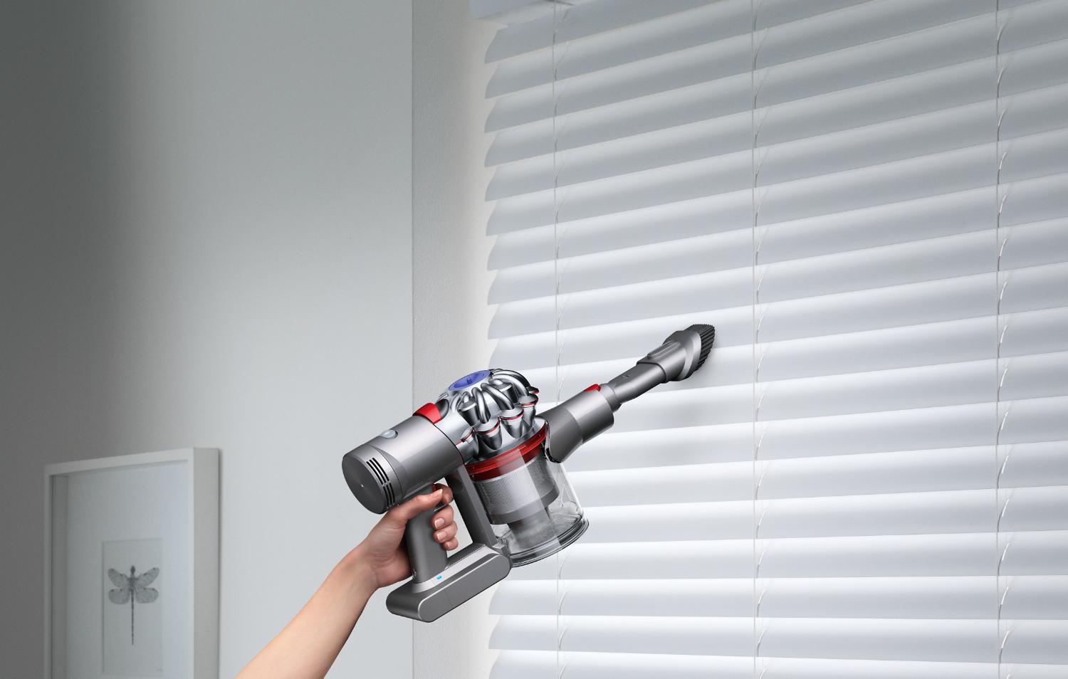 Dyson V7™ handheld vacuum on window blinds