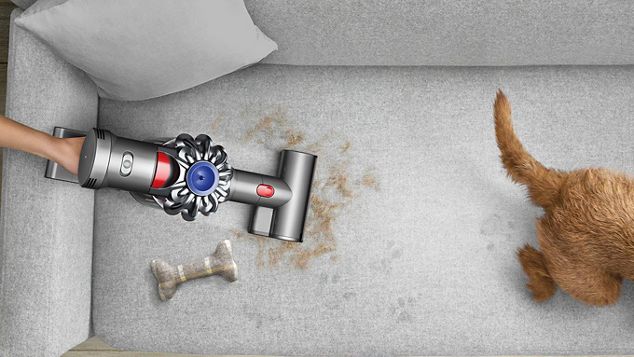 Aspirateur à main Dyson V7™ utilisé pour nettoyer un canapé