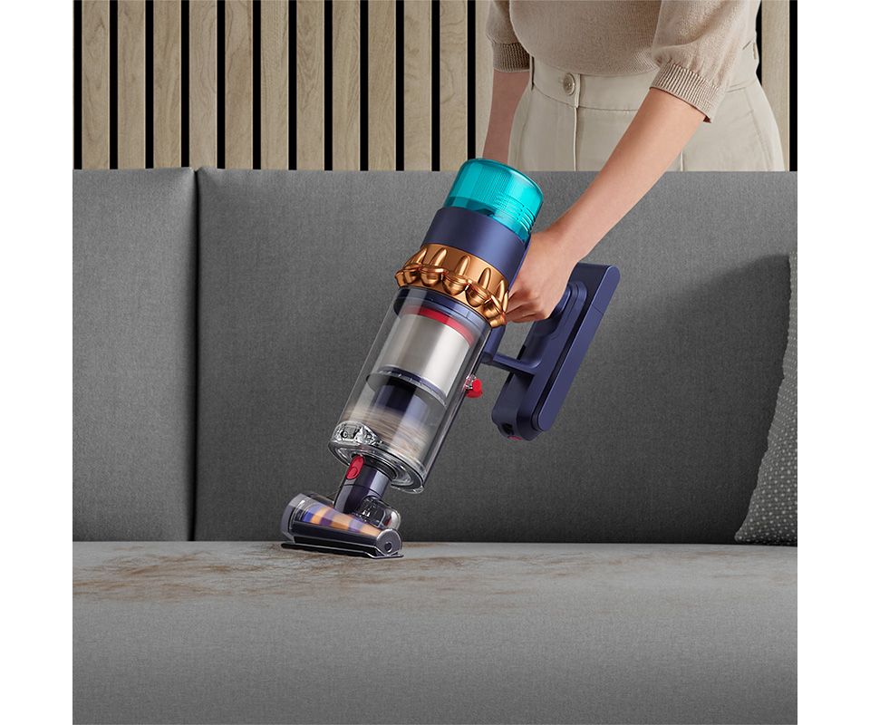 Dyson Hair screw tool vacuuming pet hair from a sofa