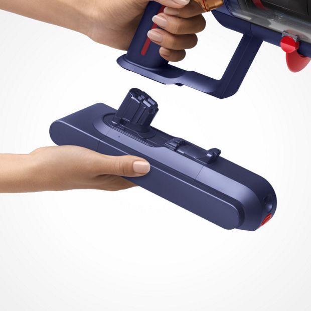 Dyson swappable battery clicking into the machine handle.