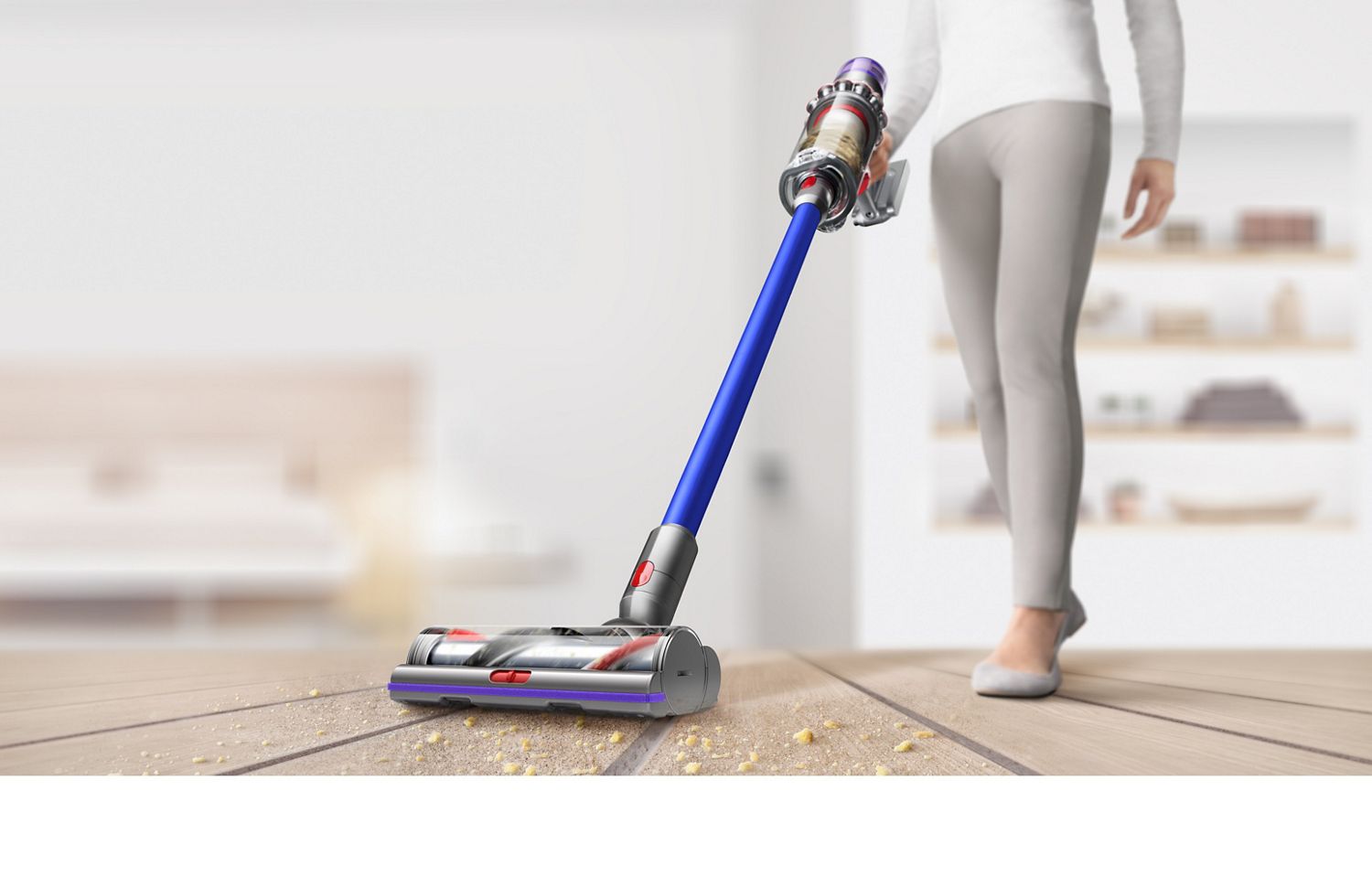 Femme utilisant l'aspirateur sans fil Dyson V11