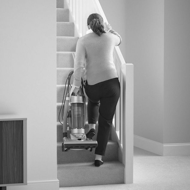 Vacuum cleaner being carried up stairs