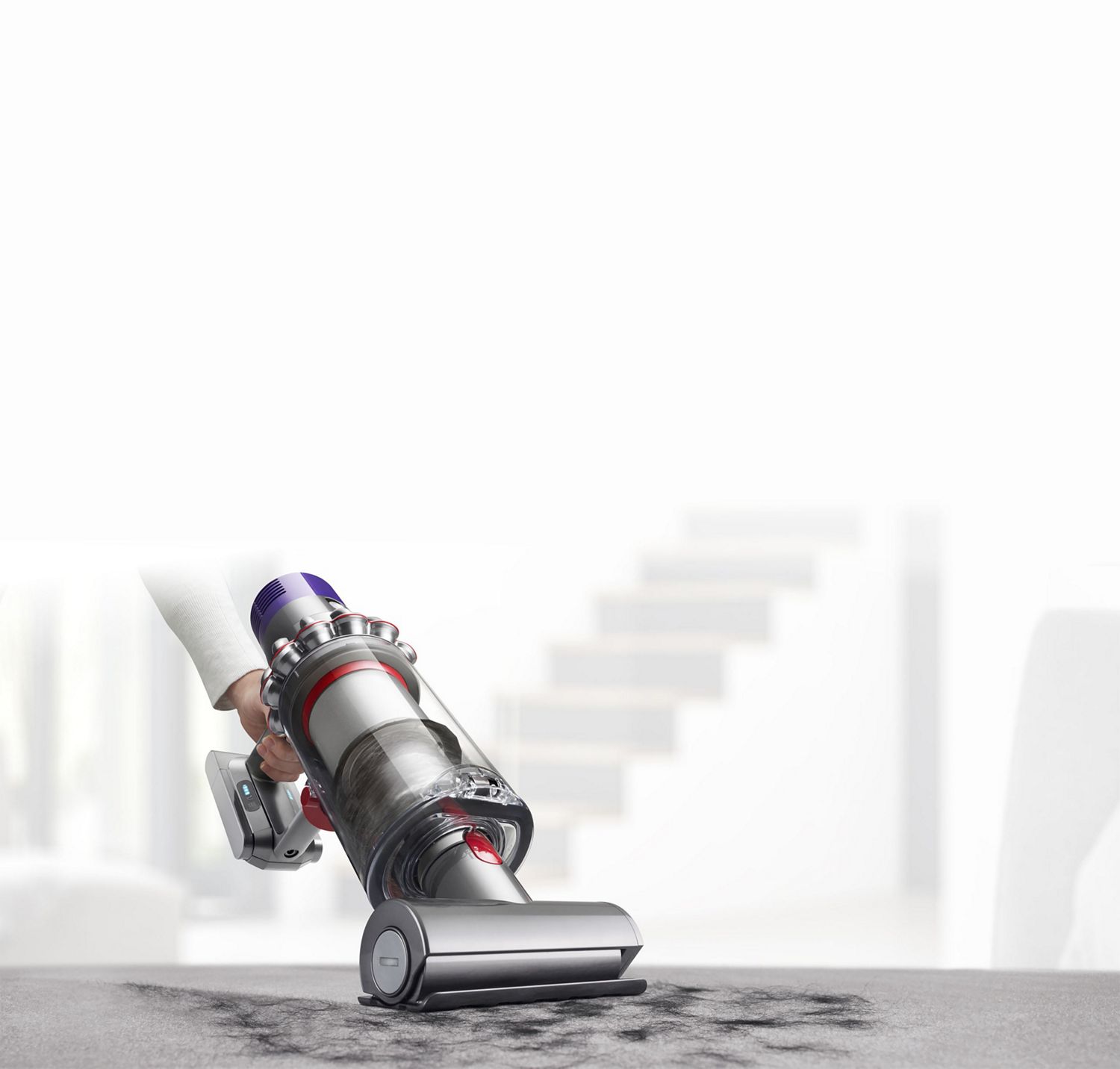  Dyson Cyclone V10™ vacuum in handheld mode cleaning upholstery