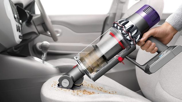 Dyson Cyclone V10™ vacuum in handheld mode cleaning car seat Dyson Cyclone V10™ vacuum in handheld mode cleaning car seat
