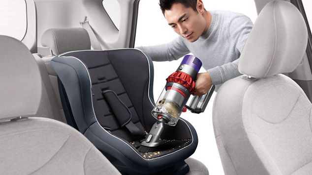 Dyson Cyclone V10™ vacuum in handheld mode cleaning car seat