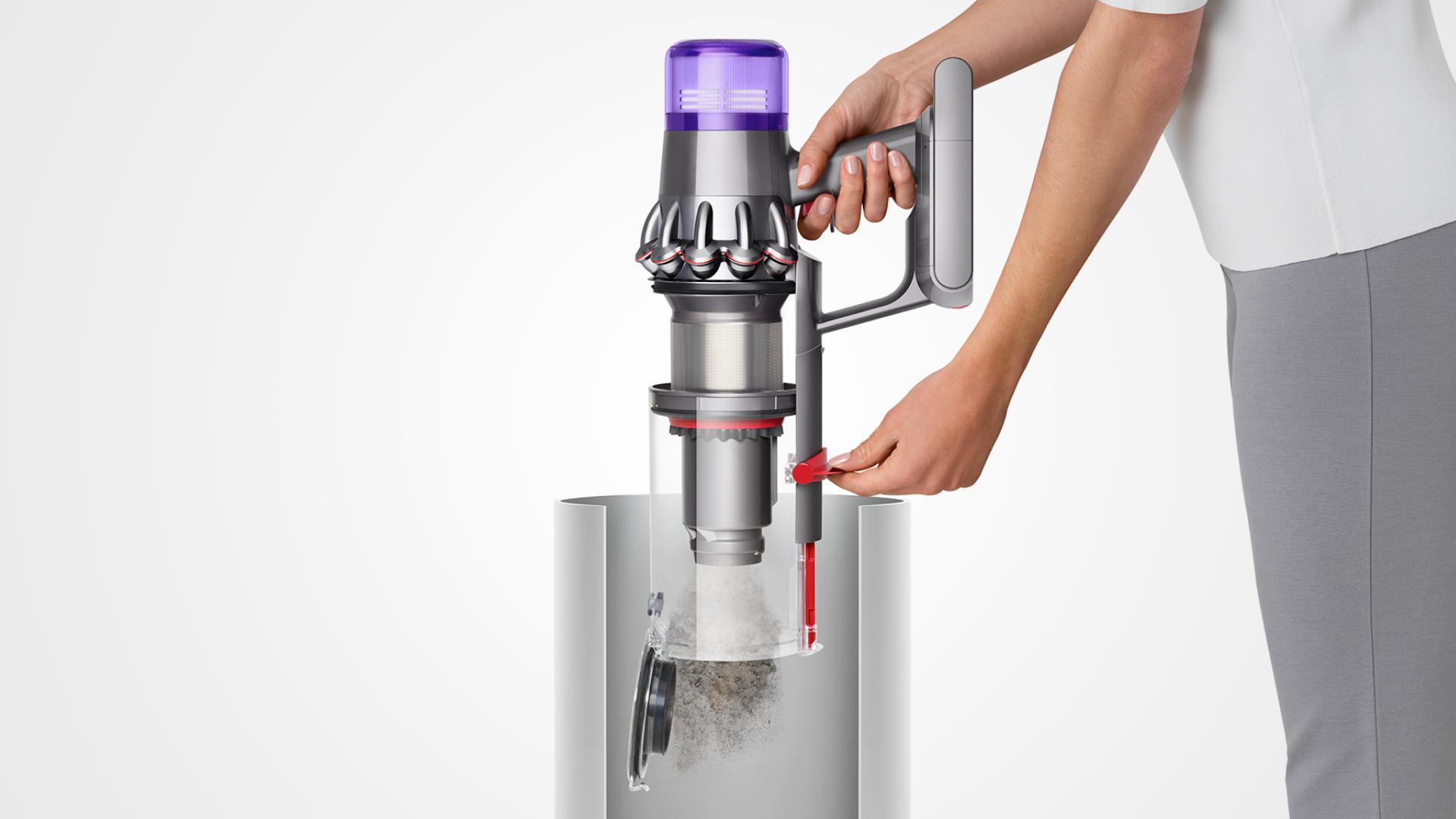 Woman emptying Dyson V11™ vacuum into bin