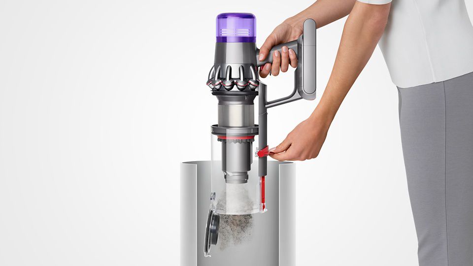  Kvinde, der tømmer Dyson V11™ støvsugeren ned i en skraldespand