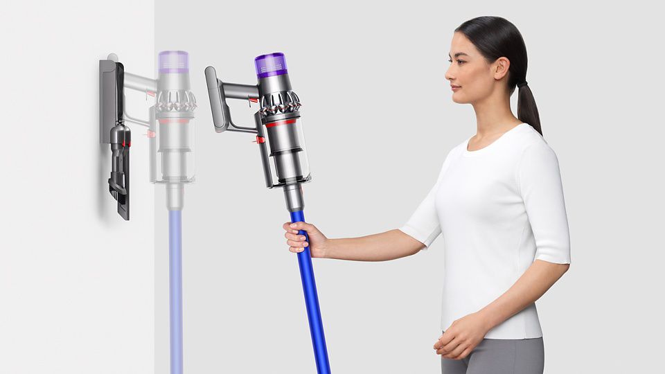  Kvinde, der placerer Dyson V11™ støvsugeren i den vægmonterede dockingstation