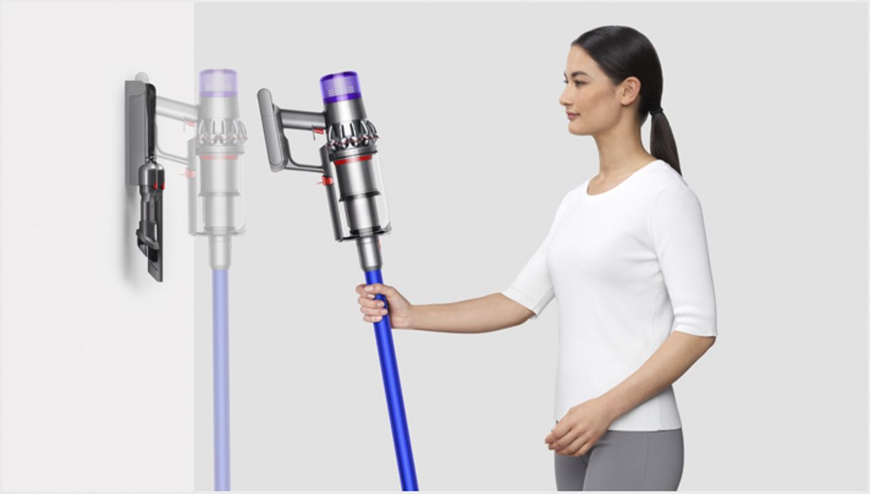 Donna che ripone Dyson V11™ nella stazione di ricarica a parete Donna che ripone Dyson V11™ nella stazione di ricarica a parete