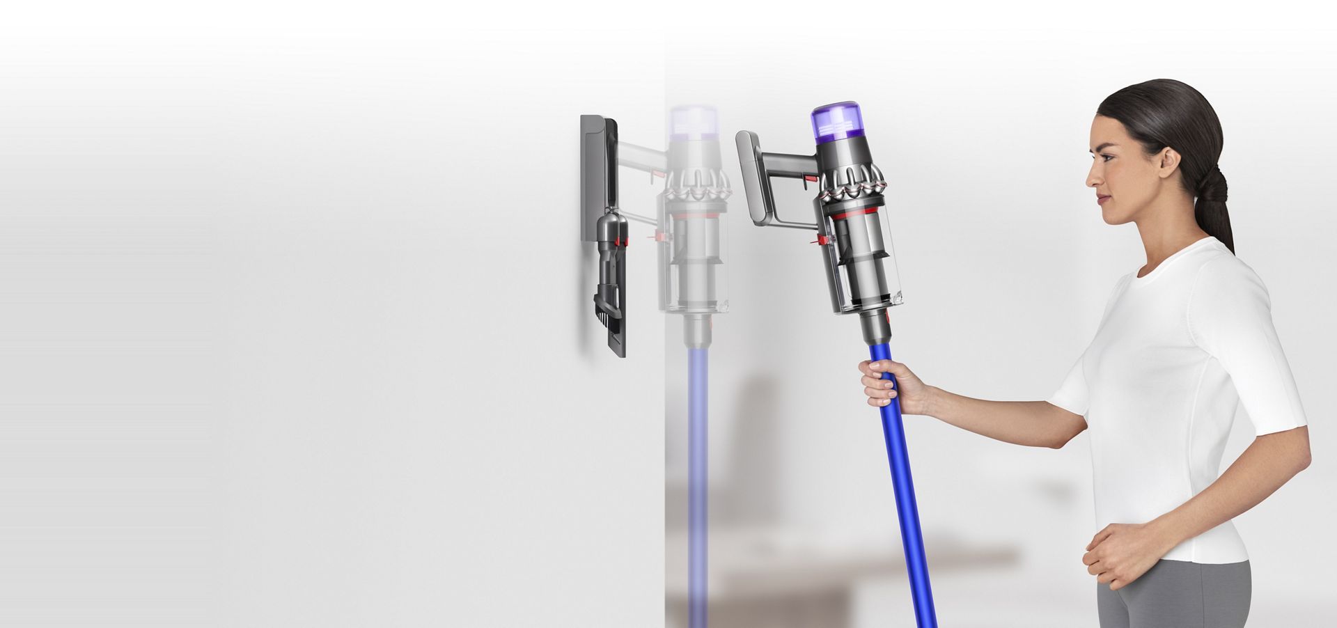 Kvinne som setter en Dyson V11™ støvsuger inn i den veggmonterte ladestasjonen
