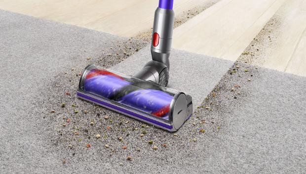 Woman cleaning floor using Dyson cyclone V10 vacuum cleaner