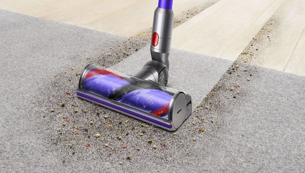Woman cleaning floor using Dyson cyclone V10 vacuum cleaner 