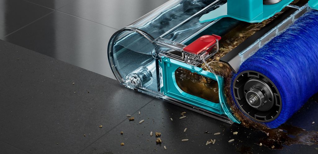 Motorised wet roller on a stone floor with some debris to the front and side leaving behind a clean sheen.