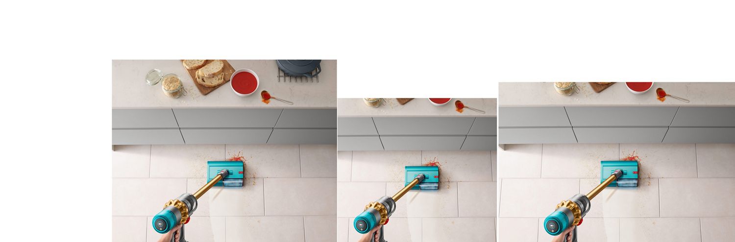 Dyson V15s Detect Submarine Absolute wet roller head clearing up spilt soup and breadcrumbs. Dyson V15s Detect Submarine wet roller head clearing up spilt soup and breadcrumbs on a tiled kitchen floor near a countertop.