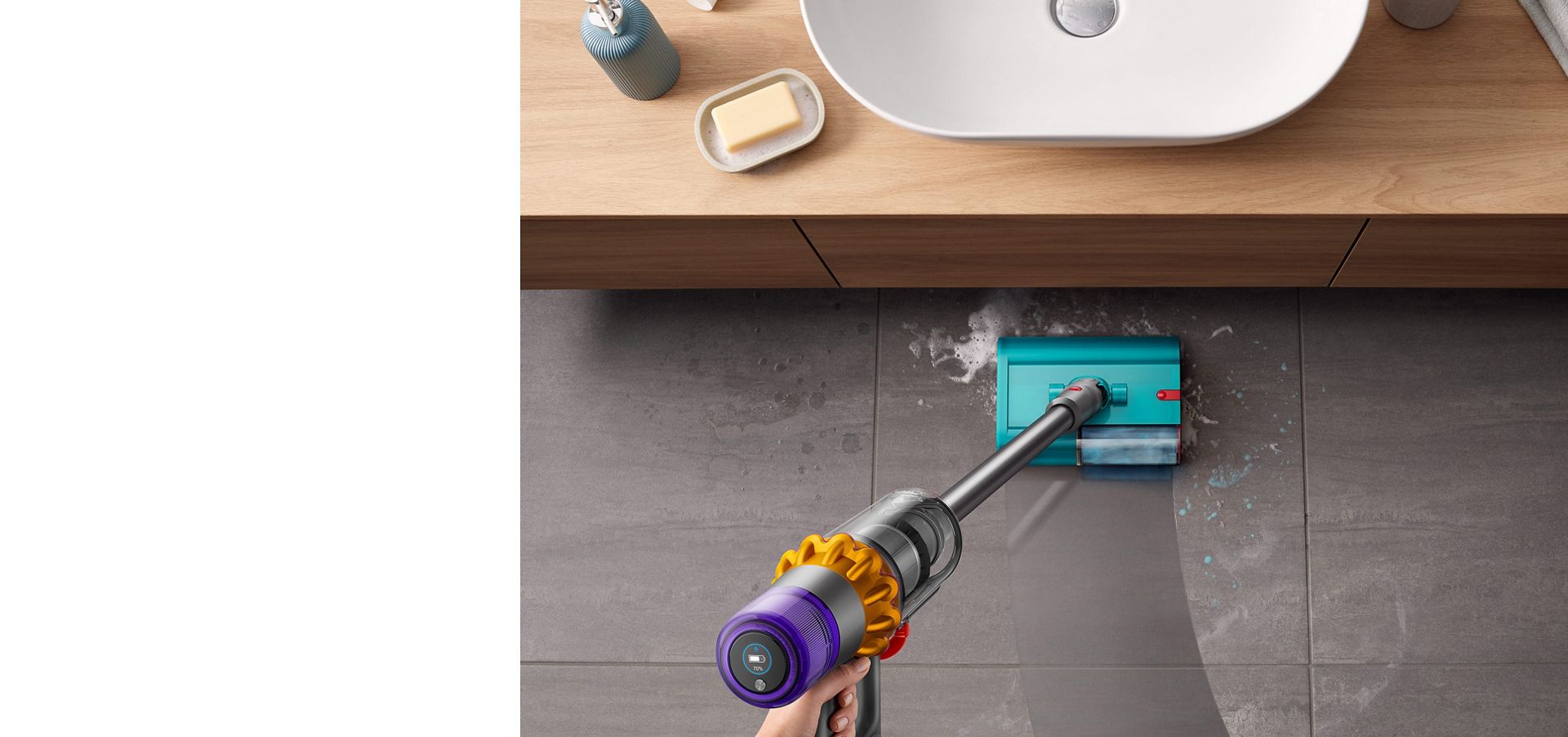 Dyson V15s Detect Submarine wet roller head cleaning a tiled bathroom floor from soapy water and toothpaste with a basin located to the front.