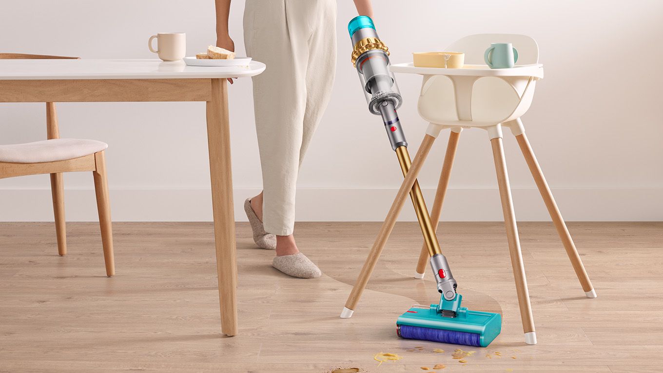 Dyson V15s Detect Submarine wet roller head angled in between a high chairs legs.