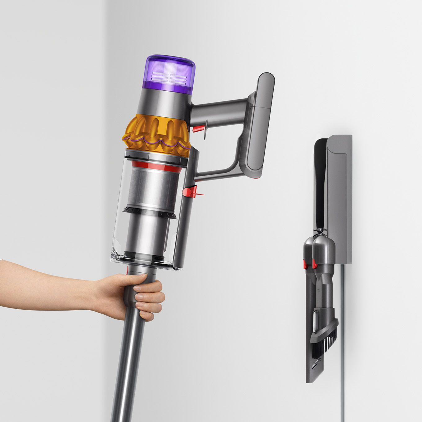 User placing Dyson V15s Detect Submarine wet and dry vacuum cleaner on to the wall dock. Dyson V15s Detect Submarine wet and dry vacuum cleaner being placed on to the wall dock.