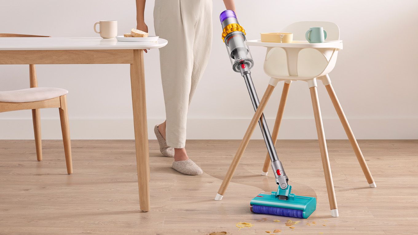 Dyson V15s Detect Submarine wet roller head angled in between a high chairs legs. Dyson V15s Detect Submarine wet roller head angled in between a high chairs legs.
