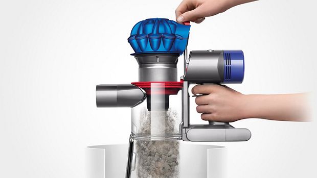 Kobieta opróżniająca zbiornik odkurzacza Dyson wprost do kosza na śmieci