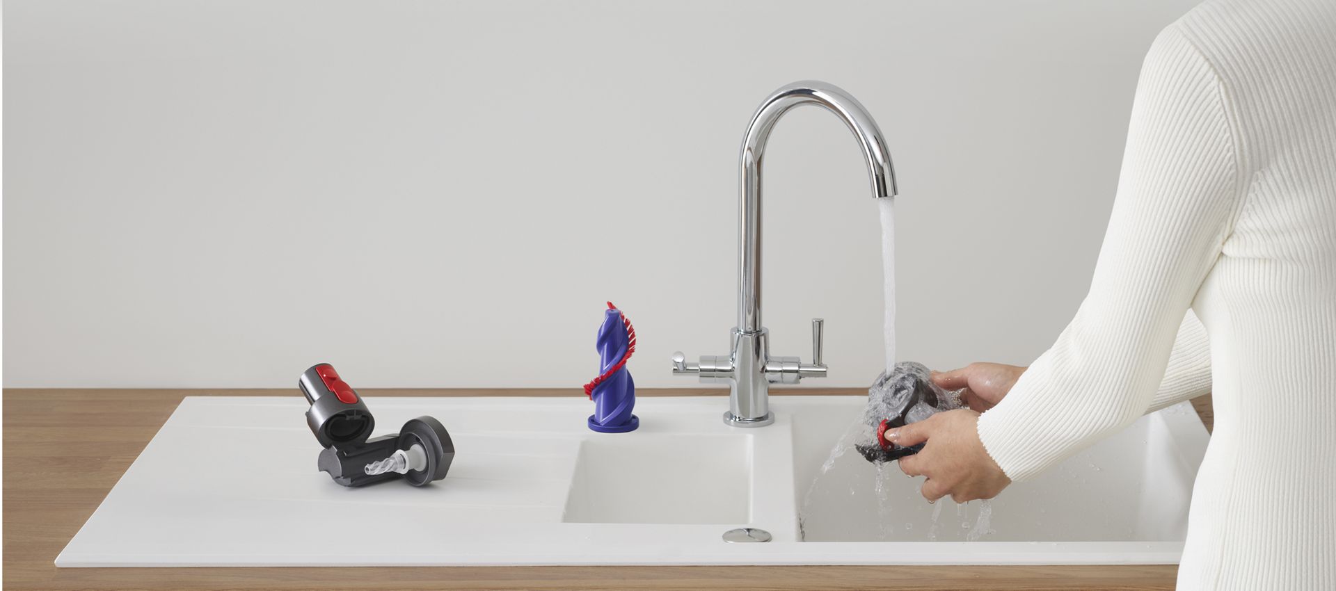 Dyson tools being cleaned at a sink