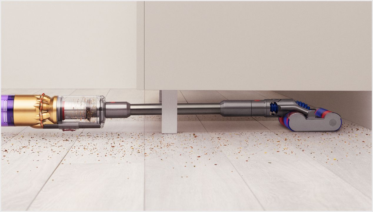 The Dyson Omni-glide vacuum cleaning under low furniture