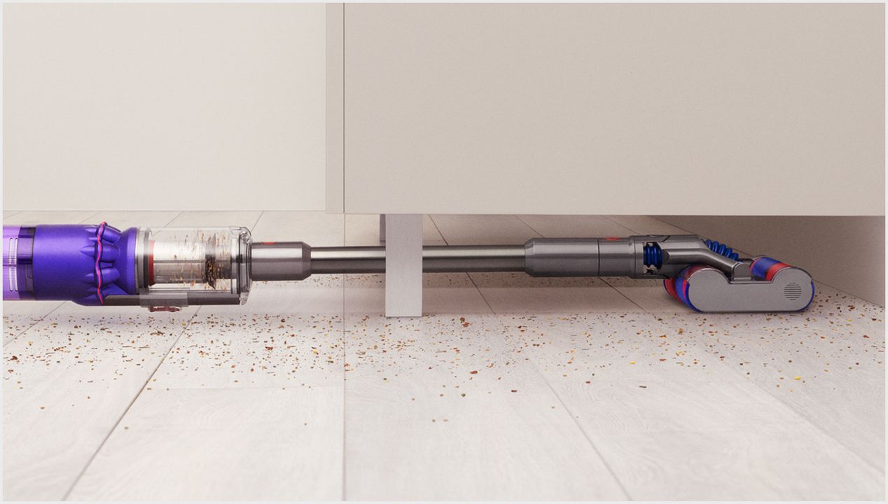 The Dyson Omni-glide vacuum cleaning under low furniture