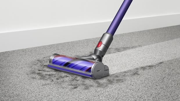 Woman cleaning floor using Dyson cyclone V10 vacuum cleaner
