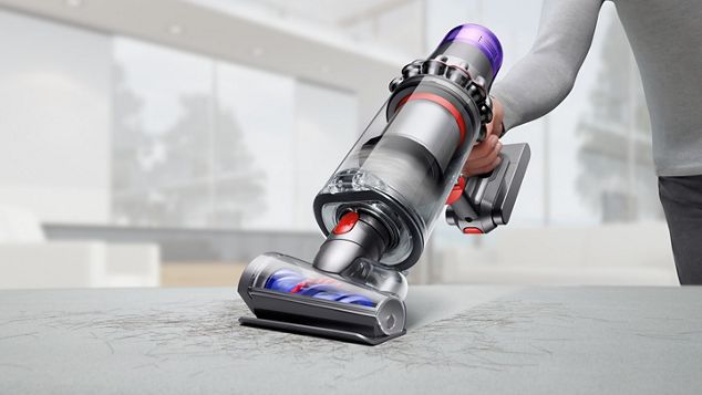 Dyson V11 in handheld mode with hair screw tool cleaning up a sofa