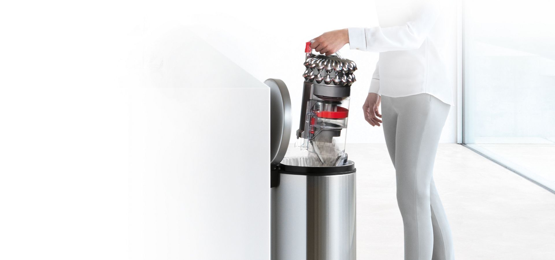 Beholderen til en Dyson Cinetic Big Ball støvsuger som tømmes i søppelkassen.