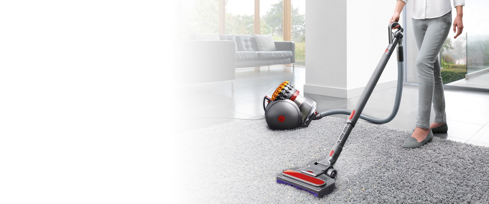 Model, der benytter en Dyson Big Ball til rengøring af tæppet i stuen. 