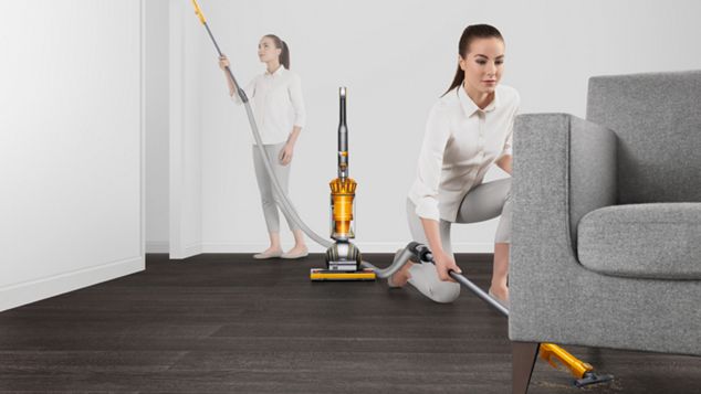 Femme utilisant l’aspirateur Dyson Ball Multi Floor 2 pour nettoyer sous un sofa
