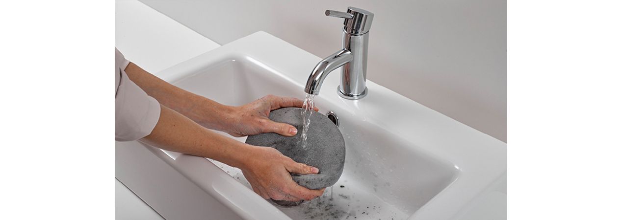 Filter being washed underneath tap