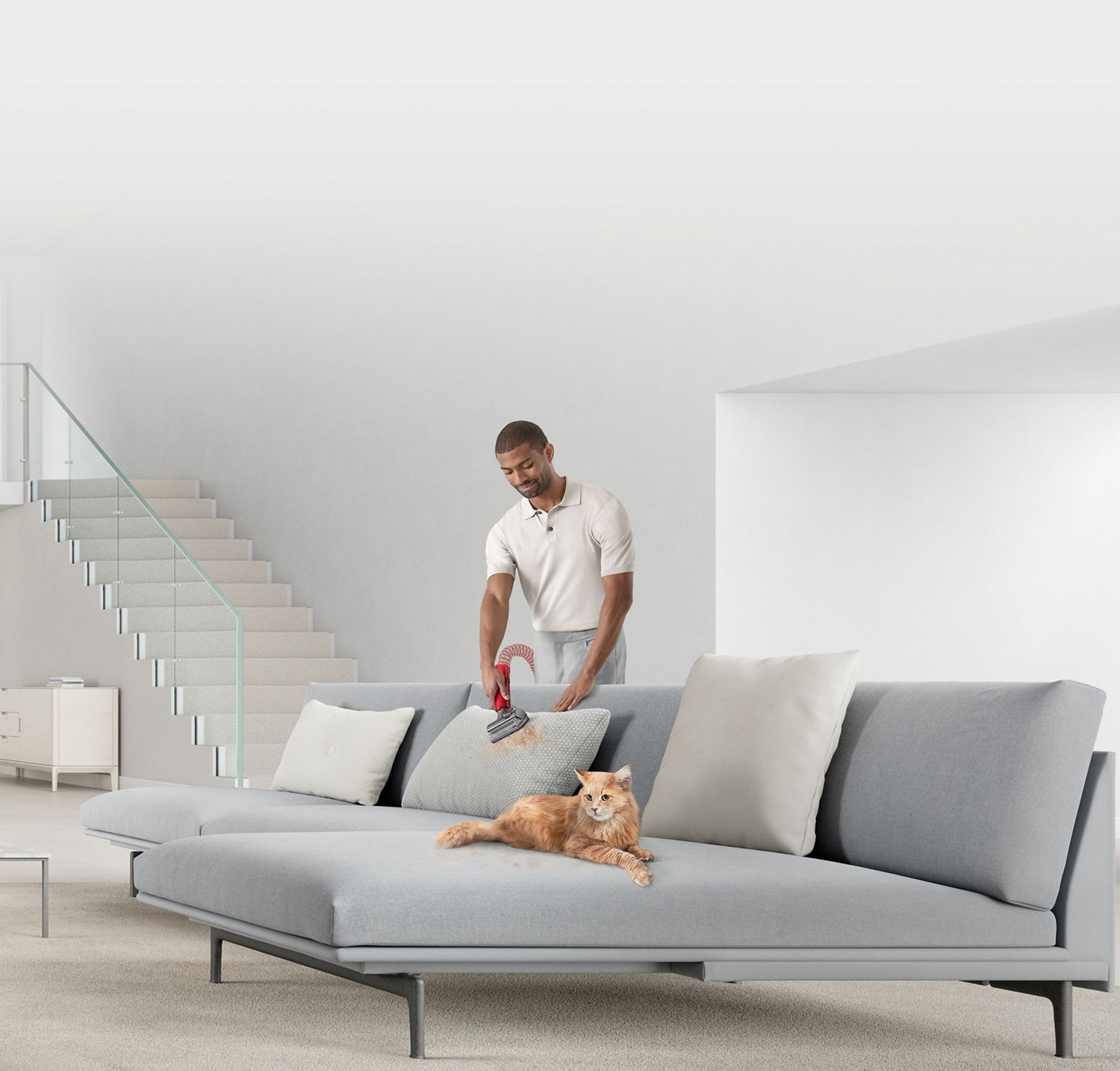 Man cleaning the sofa with Dyson vacuum