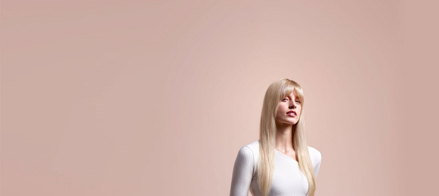 Model with smooth, straight, long blonde hair shows the finished style. Model with smooth, straight, long blonde hair shows the finished style.